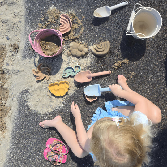 Silicone beach bucket set with shovel and sand molds for kids – BPA-free and safe, photographed on a sunny beach in Beirut, Lebanon