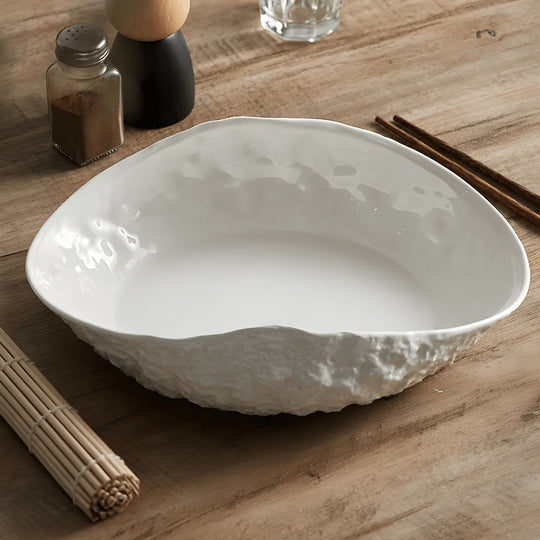 White oval ceramic dinner plate with textured rock design and curved edge – modern minimalist style for stylish meal presentation.