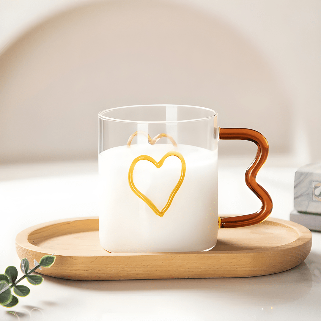 Heart-shaped clear glass mug with wavy handle and raised double-heart design