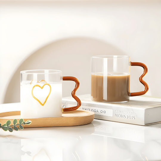 Heart-shaped clear glass mug with wavy handle and raised double-heart design