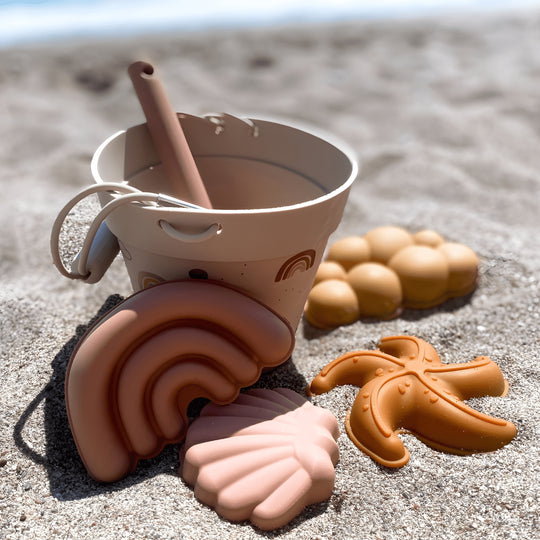 Silicone beach bucket set with shovel and sand molds for kids – BPA-free and safe, photographed on a sunny beach in Beirut, Lebanon
