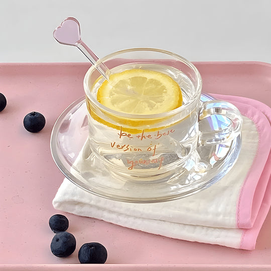 Clear 200ml glass cups with saucers and stirrers, each with a motivational quote and unique stirrer design – perfect for hot or cold beverages in Beirut.