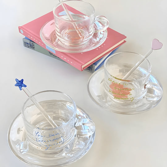 Clear 200ml glass cups with saucers and stirrers, each with a motivational quote and unique stirrer design – perfect for hot or cold beverages in Beirut.