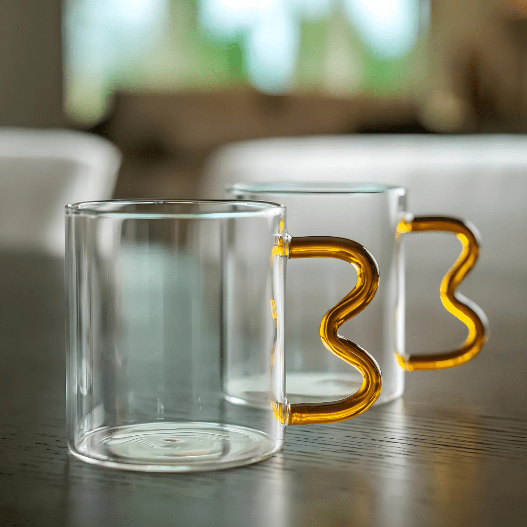 Heart-shaped clear glass mug with wavy handle and raised double-heart design