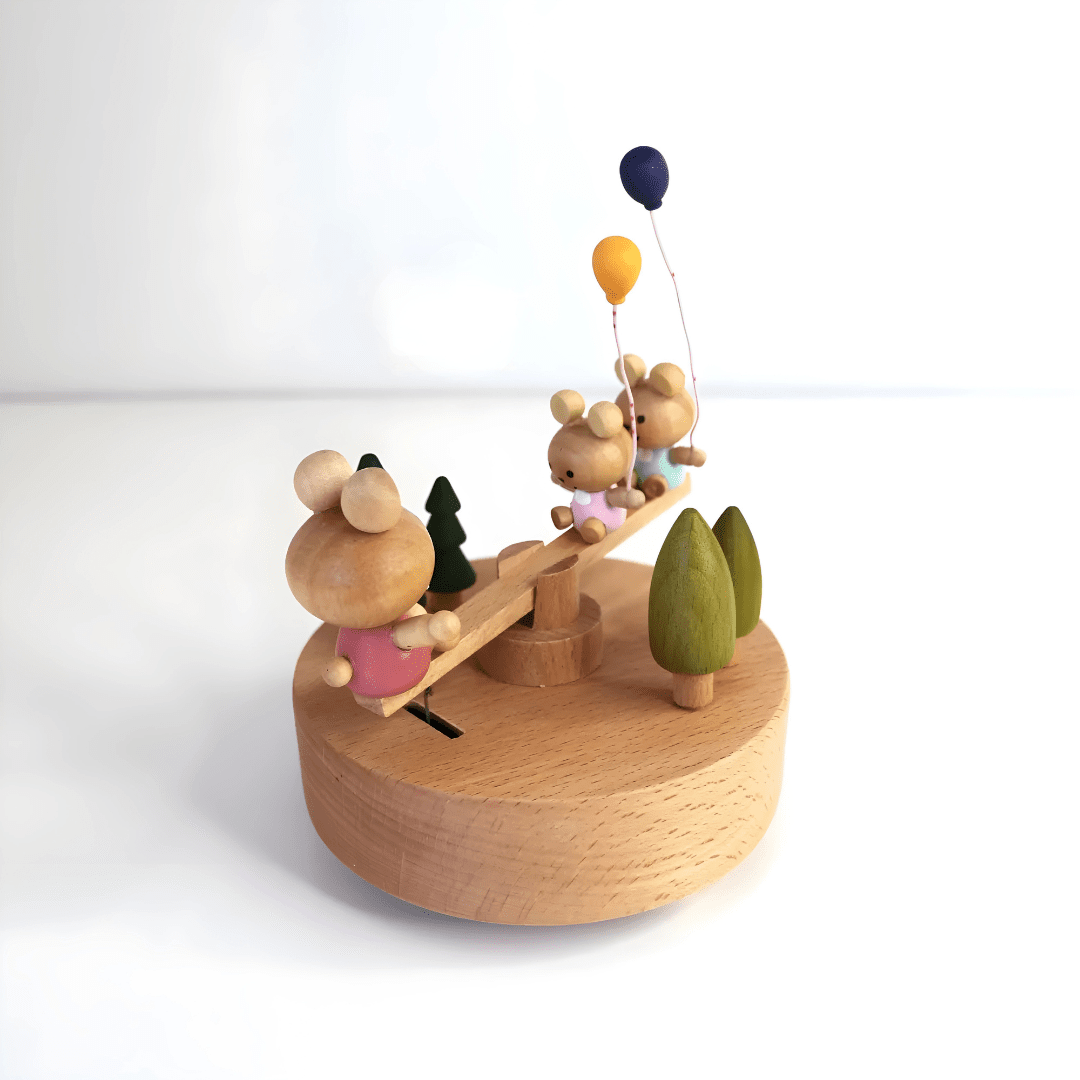 Wooden bunny family music box playing melody with moving seesaw
