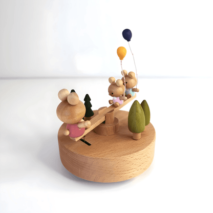Wooden bunny family music box playing melody with moving seesaw