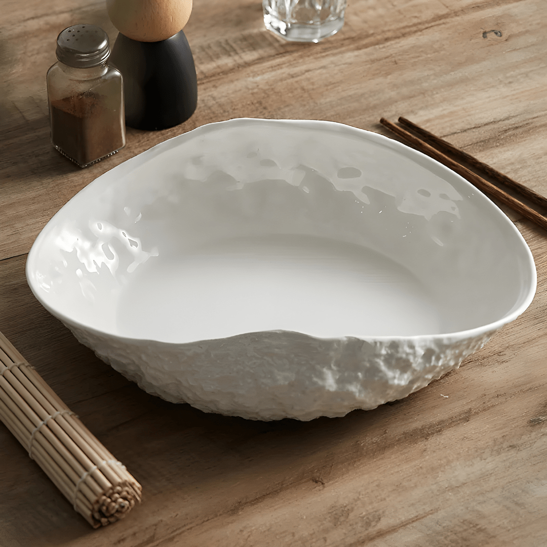 White oval ceramic dinner plate with textured rock design and curved edge – modern minimalist style for stylish meal presentation.