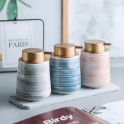 Matte white Nordic ceramic shampoo dispenser 430ml with silver pump on a modern bathroom shelf.