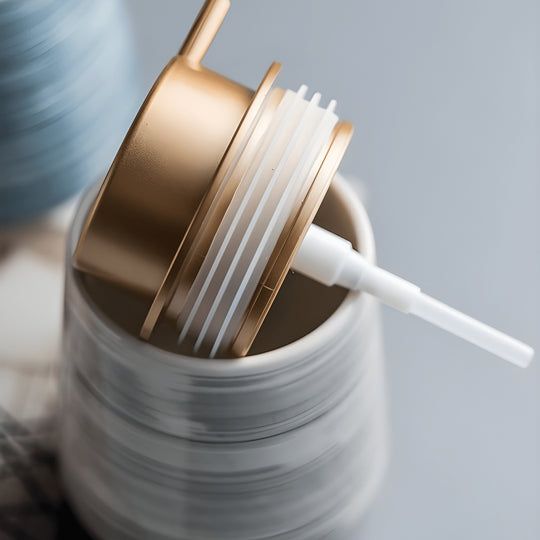 Matte white Nordic ceramic shampoo dispenser 430ml with silver pump on a modern bathroom shelf.