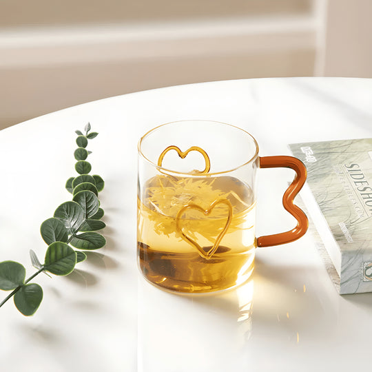 Heart-shaped clear glass mug with wavy handle and raised double-heart design