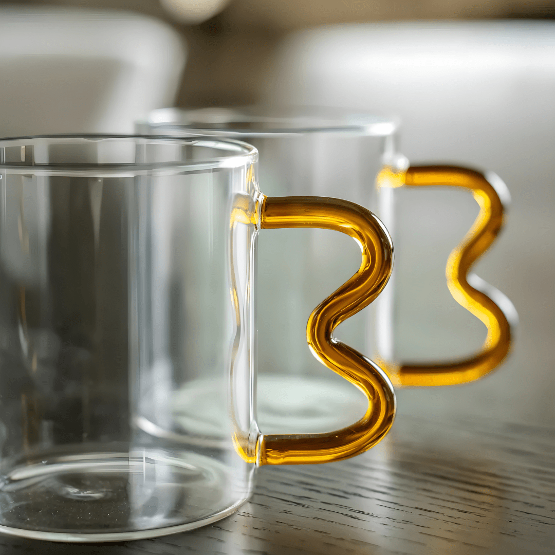 Heart-shaped clear glass mug with wavy handle and raised double-heart design