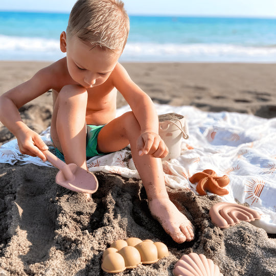 Silicone beach bucket set with shovel and sand molds for kids – BPA-free and safe, photographed on a sunny beach in Beirut, Lebanon