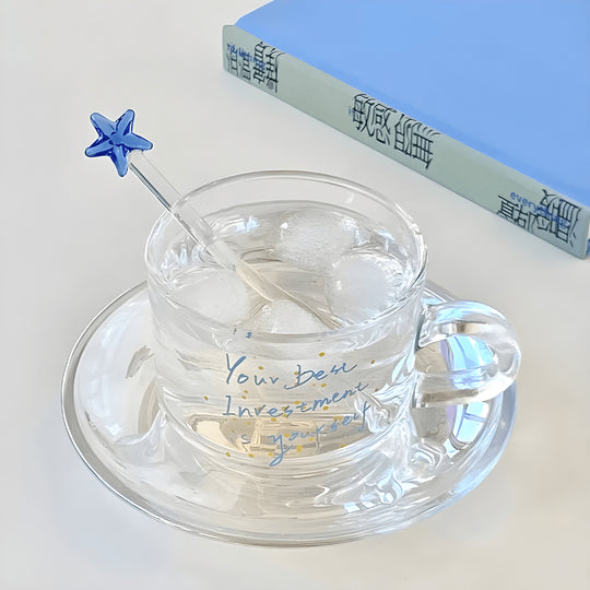 Clear 200ml glass cups with saucers and stirrers, each with a motivational quote and unique stirrer design – perfect for hot or cold beverages in Beirut.

