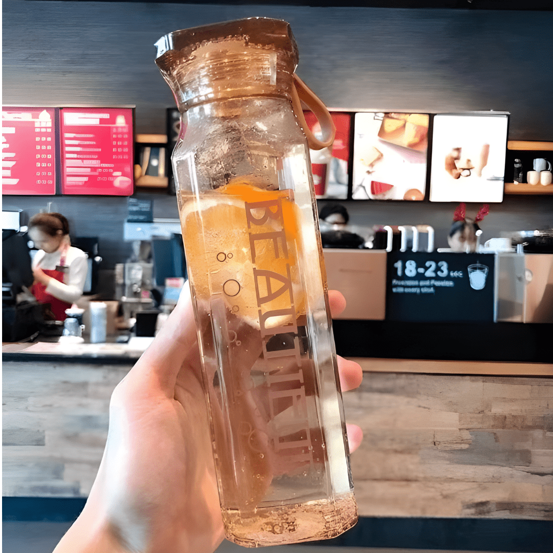 Diamond-shaped glass water bottle with fruit infusion, 500ml, available in amber, aqua, and ruby pink – eco-friendly with strap.