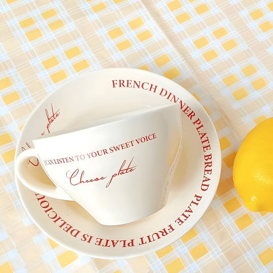 Ceramic mug with red lettering and matching saucer