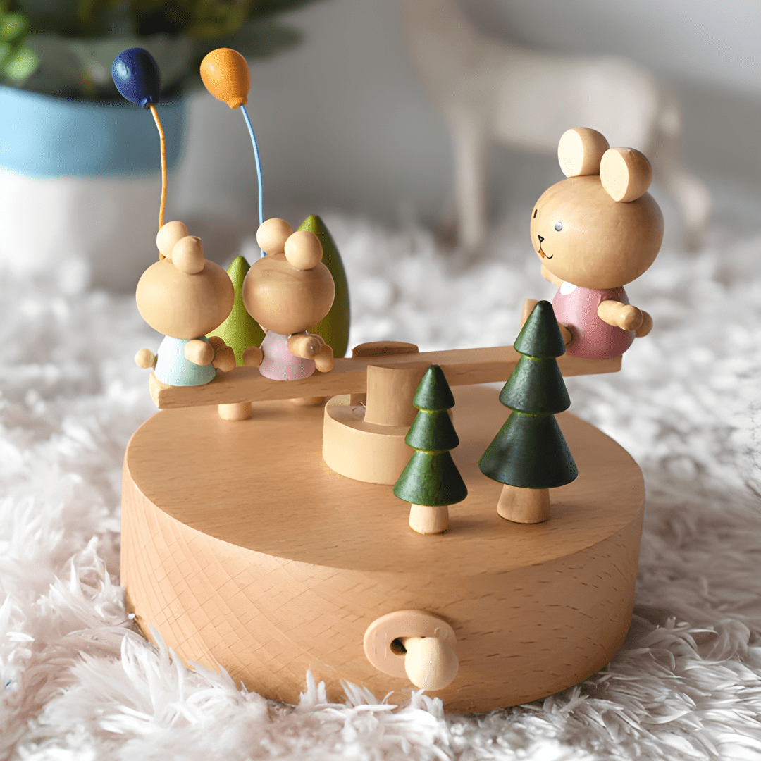 Wooden bunny family music box playing melody with moving seesaw