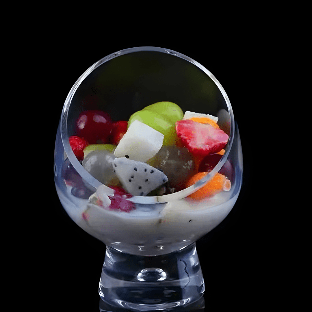 Clear tilted borosilicate glass dessert bowl with stand, 10.5×14cm – ideal for fruit salad, parfaits, and gourmet presentation.

