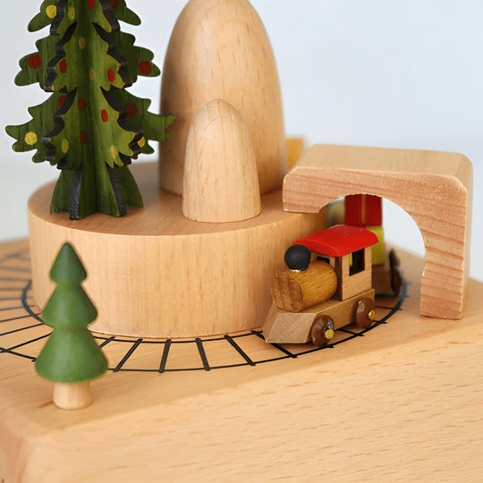 Handcrafted wooden Christmas music box with a rotating miniature train and snowy holiday scene.