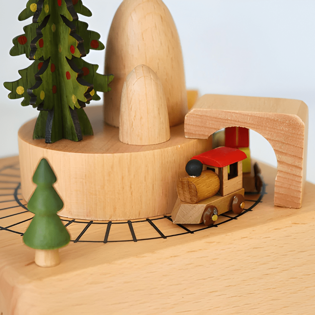 Handcrafted wooden Christmas music box with a rotating miniature train and snowy holiday scene.