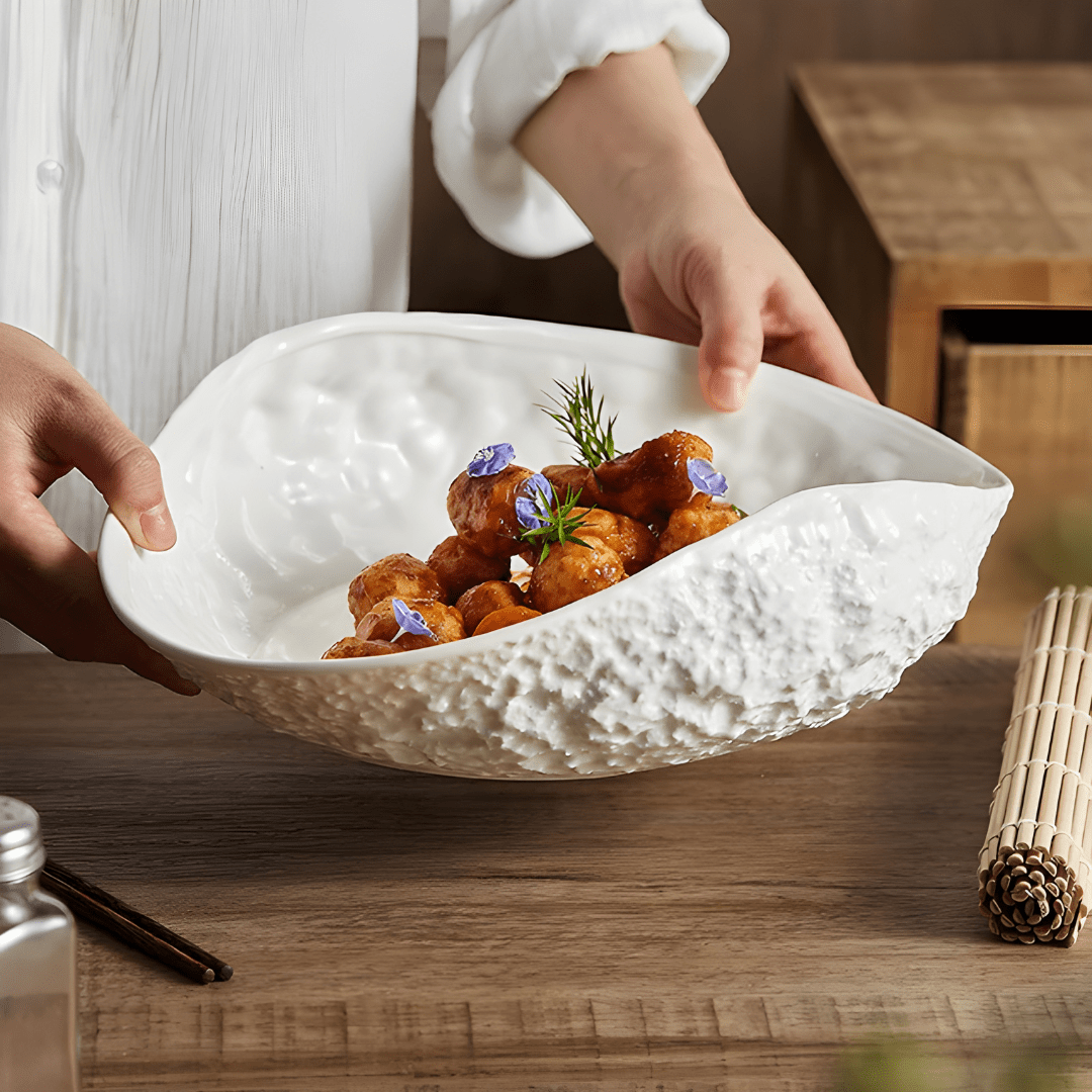 White oval ceramic dinner plate with textured rock design and curved edge – modern minimalist style for stylish meal presentation.