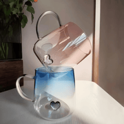Transparent borosilicate glass cups with pink and blue heart designs, featuring gradient color and elegant handles – 400ml capacity.

