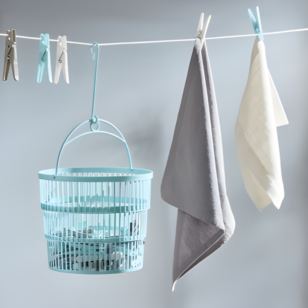 Telescopic basket with 50 clothes pegs hanging on a laundry line, practical storage for home and outdoor drying.