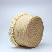 Top-down view of an empty jute storage basket with cream lace detailing around the rim