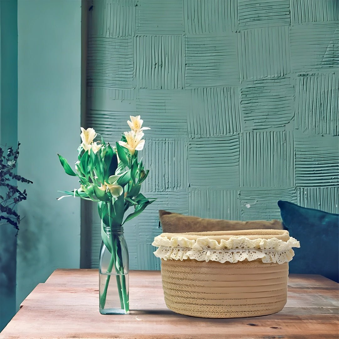 Decorative jute basket with lace trim placed on a wooden table beside a glass vase of white flowers